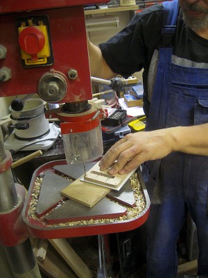 I could use off-the-shelf trem spring cavity covers, but I prefer making them of the same sheet as the pickguard. With a template that's very little trouble. Drilling the cover here.