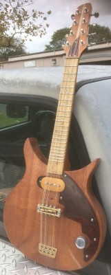 Mahogany body with bookmatched ash back cap. Mahogany/Maple/Mahogany neck with a Persimmon lacquered fretboard with a conventional one-way trussrod. Handmade brass/stainless bridge. Handmade P90 type pickup. .090 tortoise celluloid pickguard. Grover sta-tite tuners.