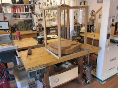 Around the island past the bandsaw is a heavy butcher-block bench that currently has my go-bar deck setup on it. The deck usually lives in the storage cabinet. I use this table for heavier work (you can see the arbor press). I also clamp machines, like the grinder, to this bench temporarily.