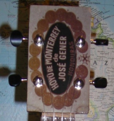 The headstock for a cigar box which matches the logo on the box.