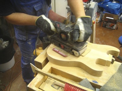 Sanding the body. The two-piece body is alder. A Strat style body takes a lot of sanding with different sanders at different stages. This is just sanding it to the correct thickness and shape.