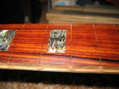 A view of the neck with the cocobolo fretboard installed and the binding route.