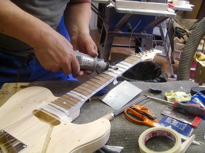 After levelling the frets I sanded them with 1200 and 2000 grit papers and polished them with polishing wax on a felt tip in a Dremel type grinder.