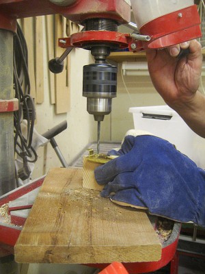 I cut the base plate out of 0.7 mm brass sheet and folded the sides and the lugs into place. Here I'm drilling the wire and screw holes to the plate.