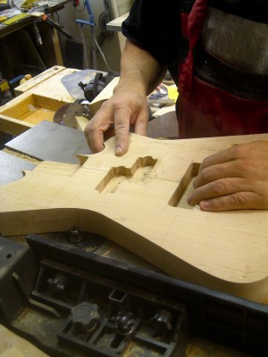 I have made routing templates for each pickup type I use in my builds and a good set of router bits for most purposes. Here I round off the body badck edge on a table router.
